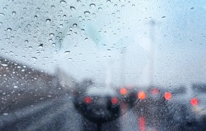 Heart painted on wet glass with traffic background